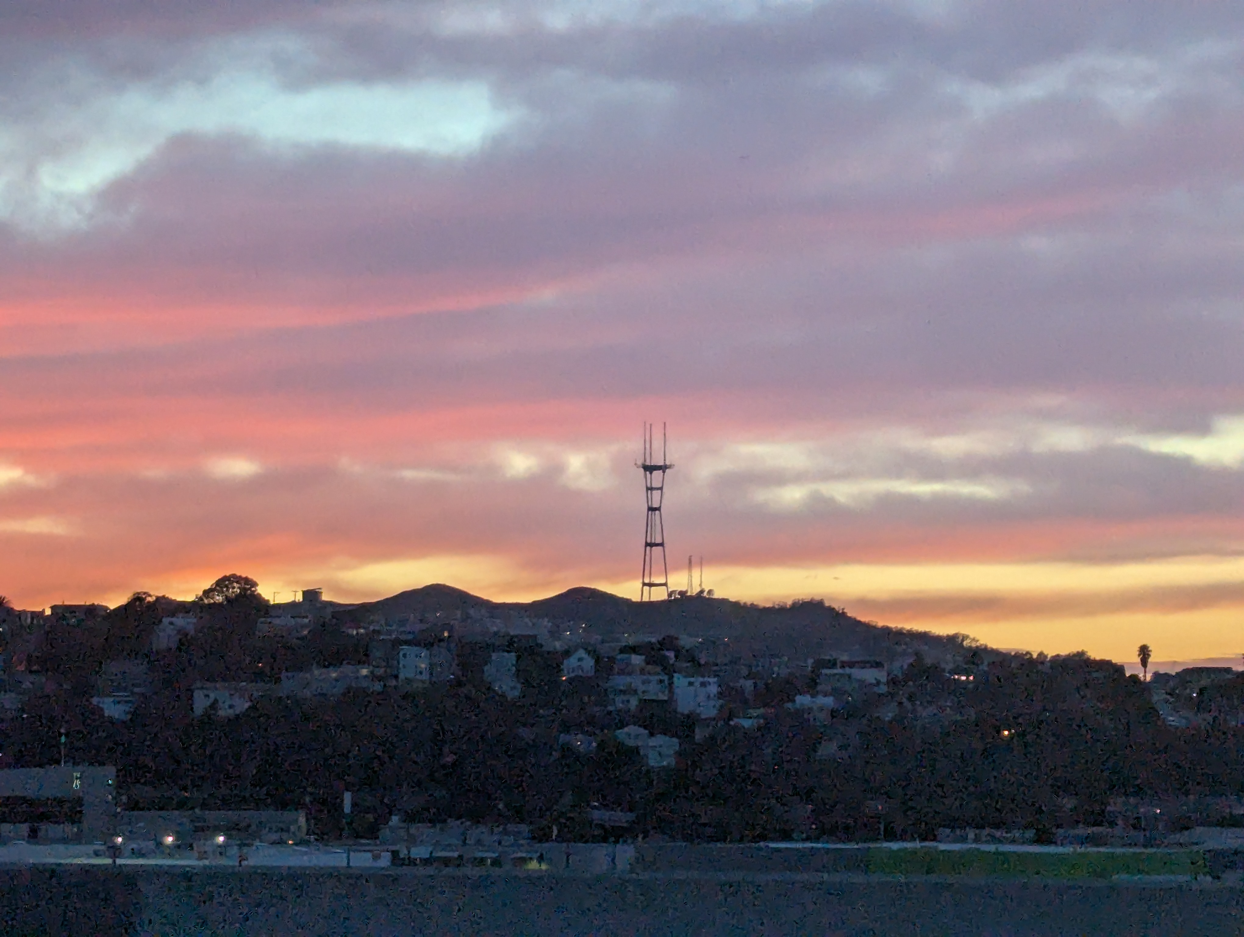 a photograph at sunset of the sutro tower in san francisco, as taken from the us-101 south highway